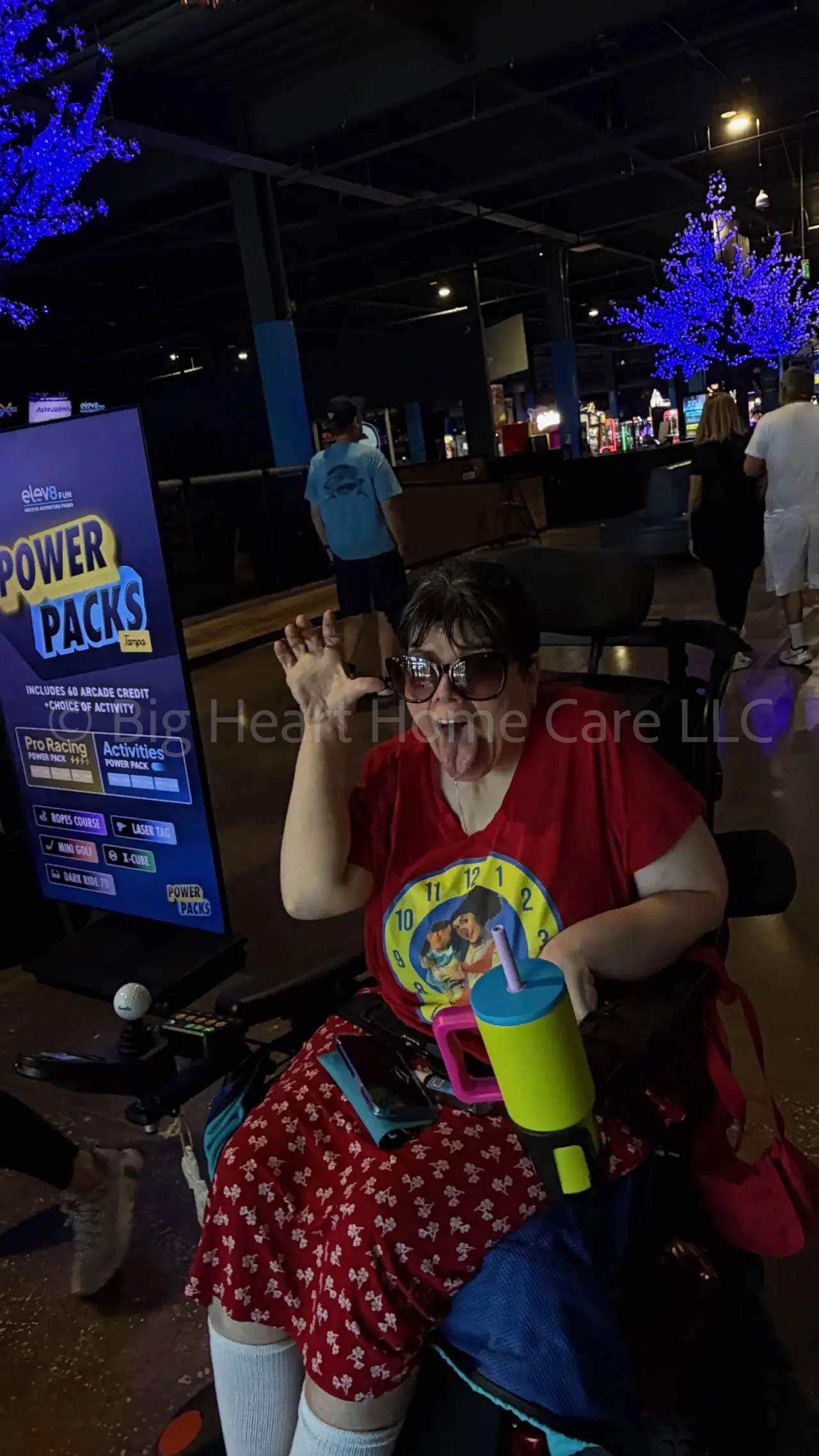 Big Heart Group Home resident smiling and playfully posing with a drink during a community outing at ELEV8 Fun Tampa in Tampa, Florida.
