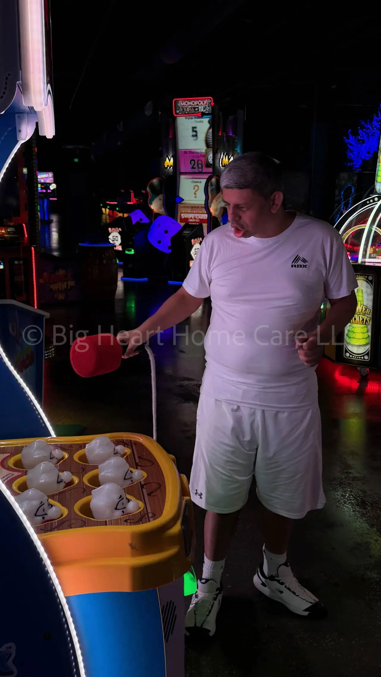 Big Heart Group Home resident concentrating while playing a light-up target arcade game at ELEV8 Fun Tampa in Tampa, Florida.